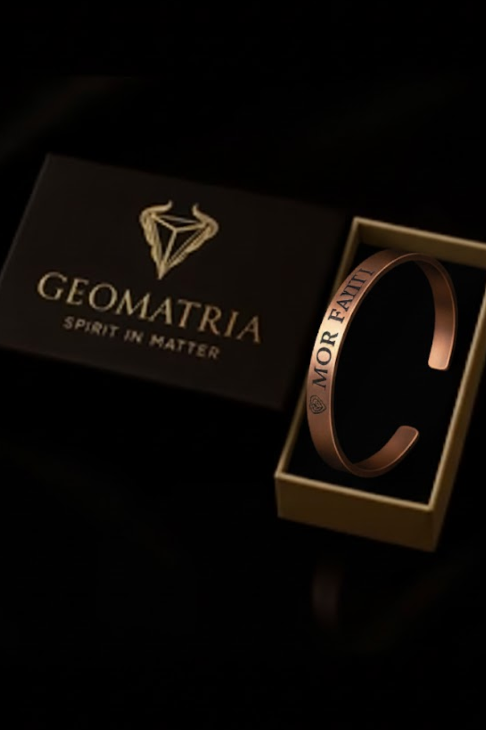A bracelet is displayed in a gold box with the text "Geomatria SPIRIT IN MATER" printed on it.