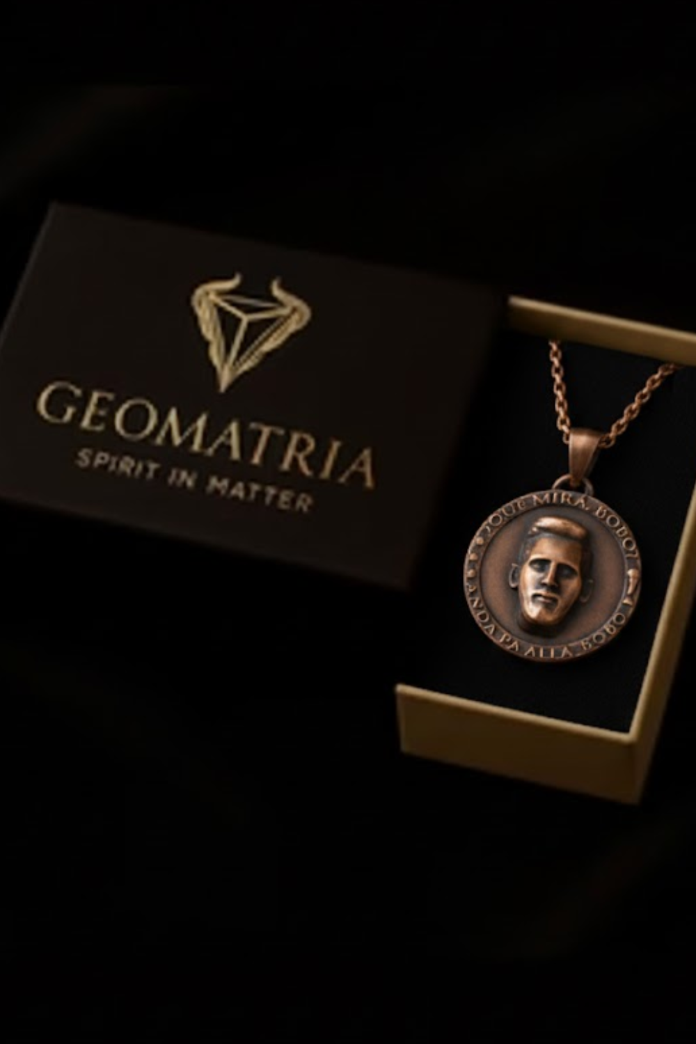 a pendant necklace with a circular pendant, placed inside a gold-colored box with the text "Geomatria" printed on it.