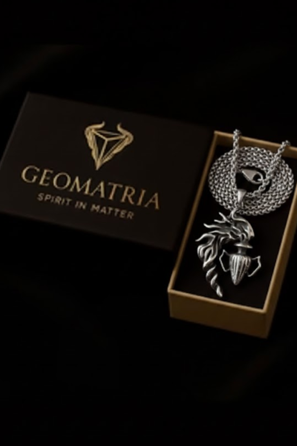 a necklace with a pendant and a box with the brand name "Geomatria" printed on it.