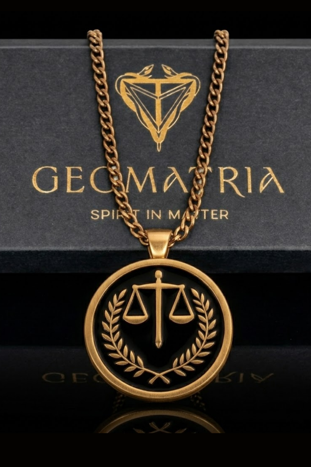 a gold-colored pendant necklace with a circular design on a black background, displaying a scale of justice symbol.