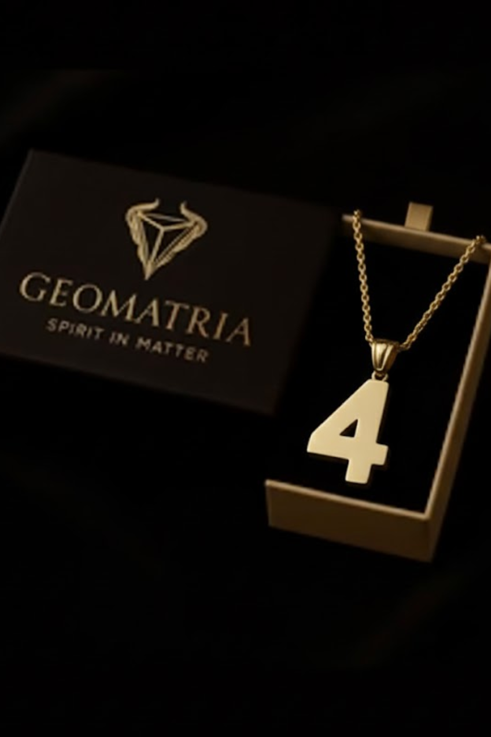 A gold-colored necklace with the number 4 pendant is displayed in a black box with the text "Geomatria" and "SPIRIT IN MATTERS" printed on it.