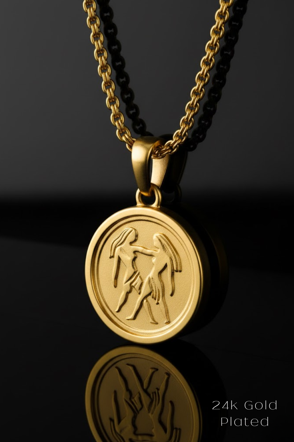 A 24k gold plated pendant featuring a circular medallion with an engraved design, hanging from a chain against a black background.