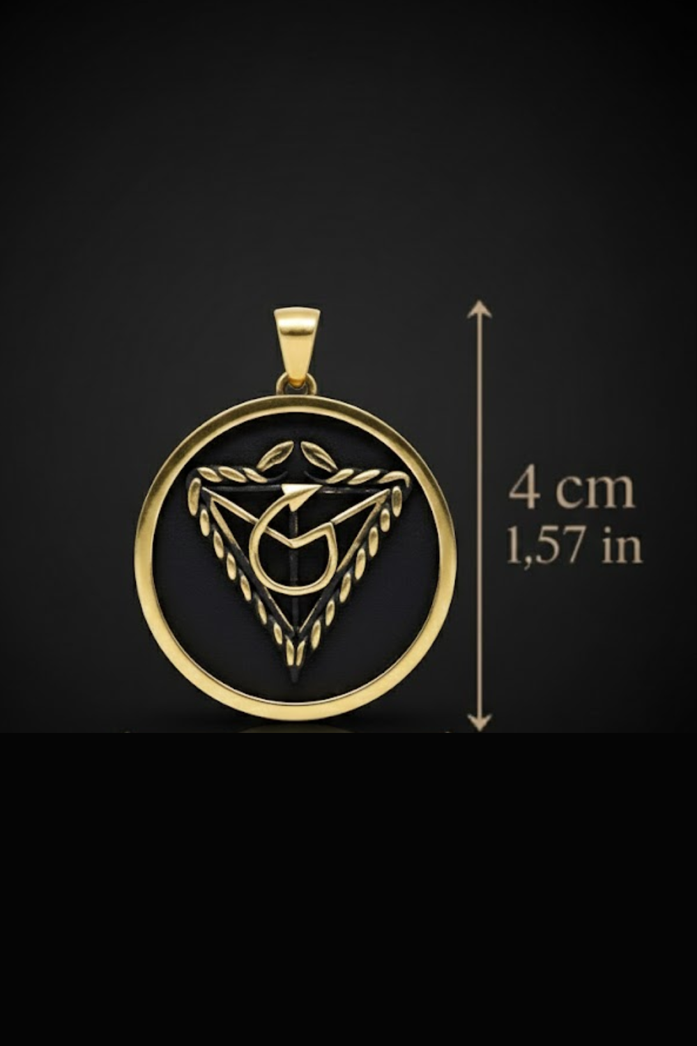 A gold-colored pendant with a black circular design, featuring a stylized symbol or emblem, is shown against a black background.