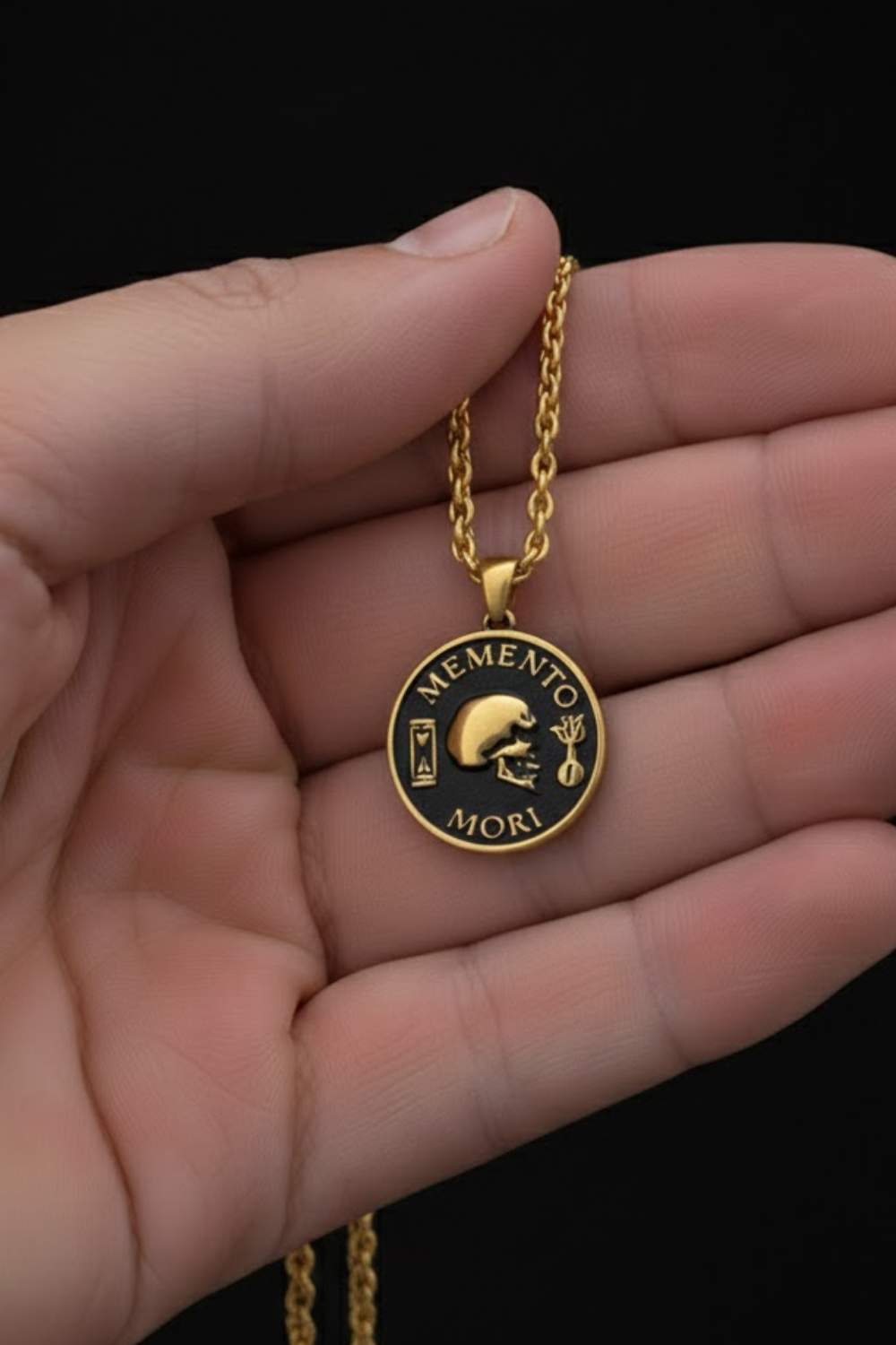 A gold-colored pendant necklace with a circular medallion featuring the Latin phrase "MEMENTO MORI" and a skull image.