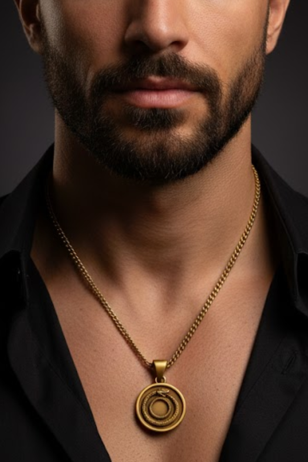 A close-up of a man's neck and chest area, with a gold necklace featuring a circular pendant prominently displayed.