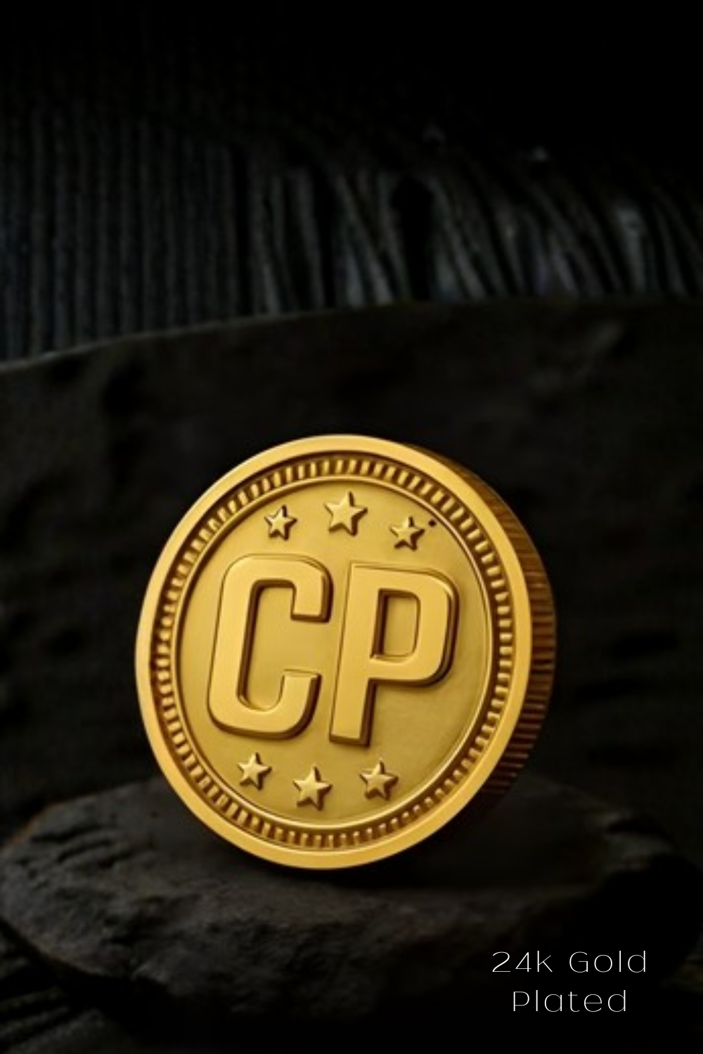 A 24k gold-plated coin with the letters "CP" prominently displayed on it.