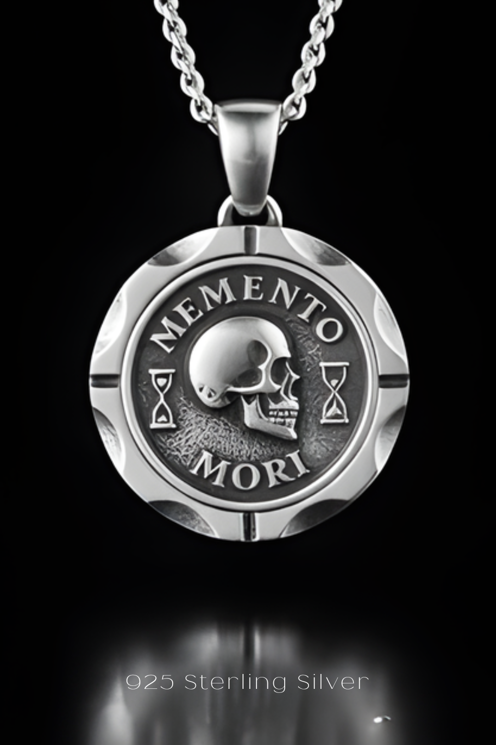 A silver pendant necklace with a circular medallion featuring a skull and the Latin phrase "MEMENTO MORI" (Memento mori).