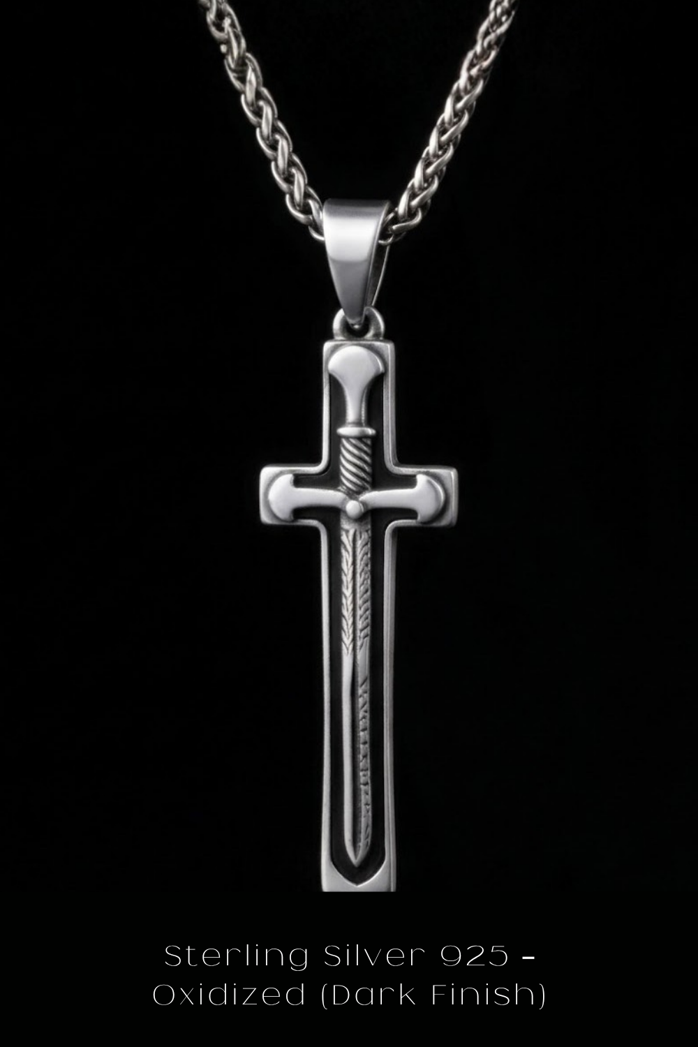 A silver cross pendant with a twisted design, suspended from a chain against a black background.