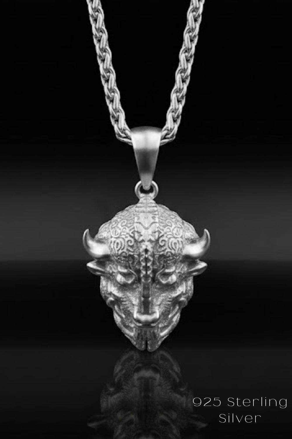 A silver pendant necklace with a detailed, sculpted bull's head design.