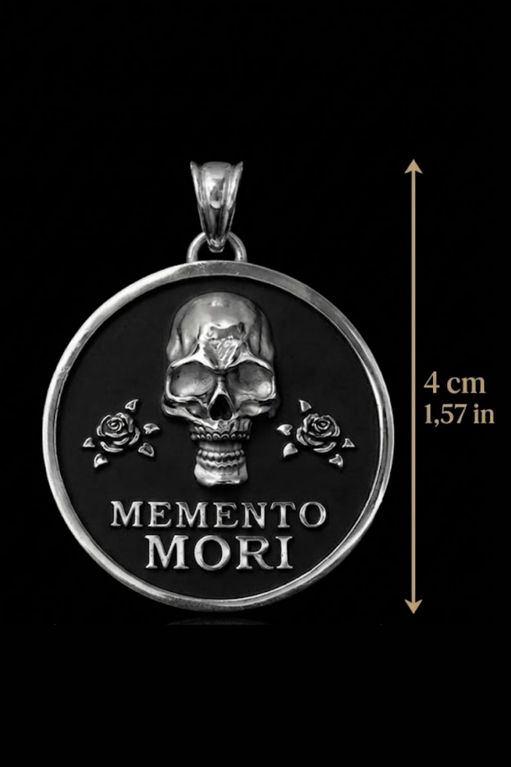 a large silver pendant with a skull design and the text "MEMENTO MORI" on it. The pendant is set against a black background, and there is a measurement scale indicating its size.
