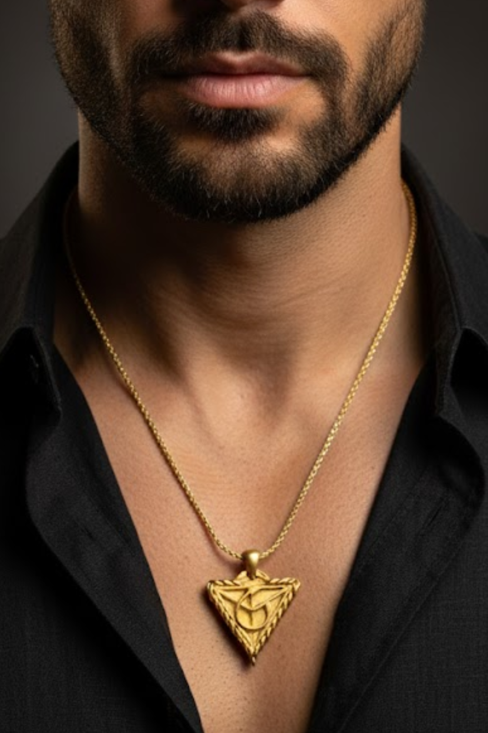 A close-up of a man's neck and chest area, with a gold necklace featuring a pendant hanging from his neck.