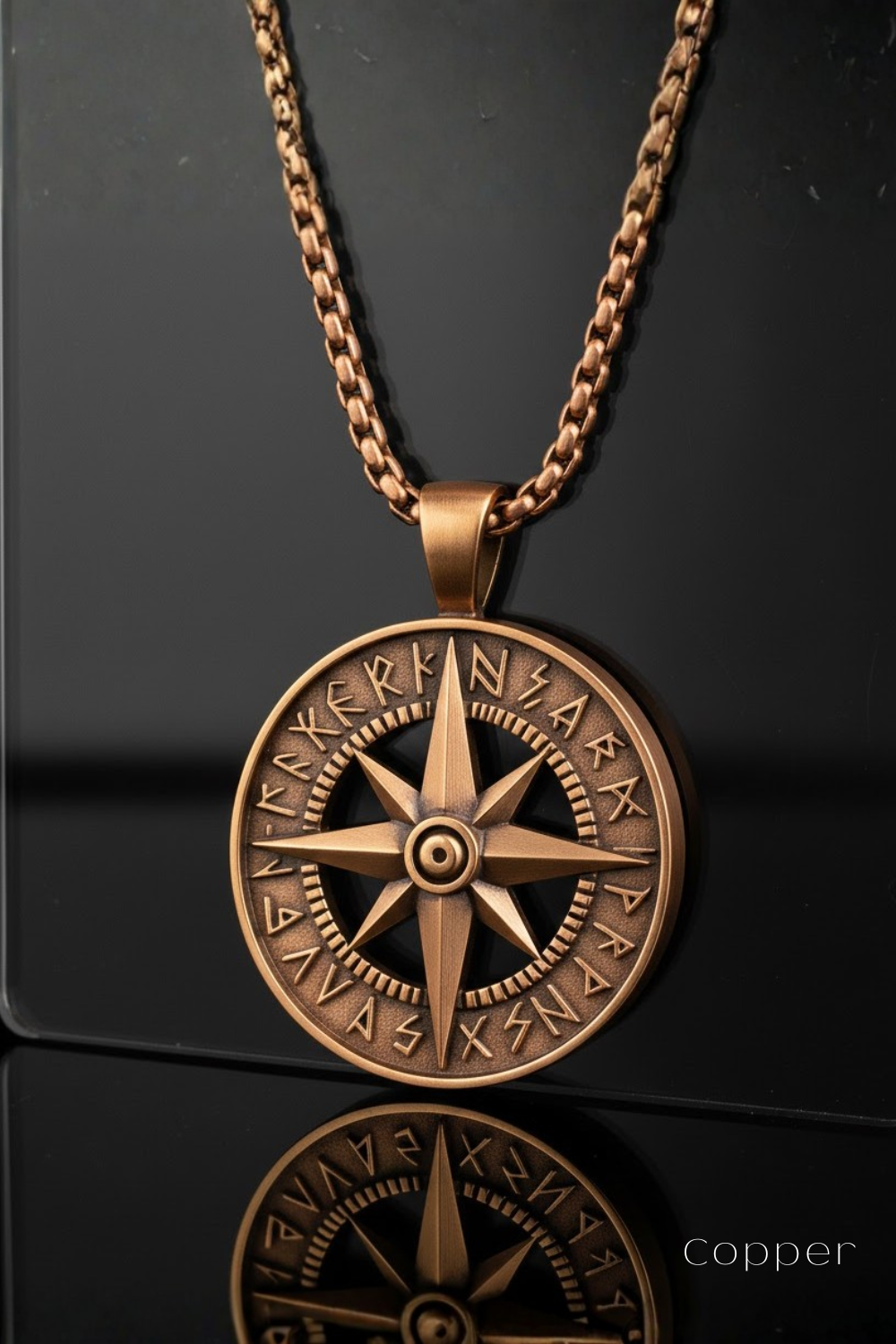 A copper-colored pendant necklace with a large compass design at the center, featuring intricate engravings and symbols.