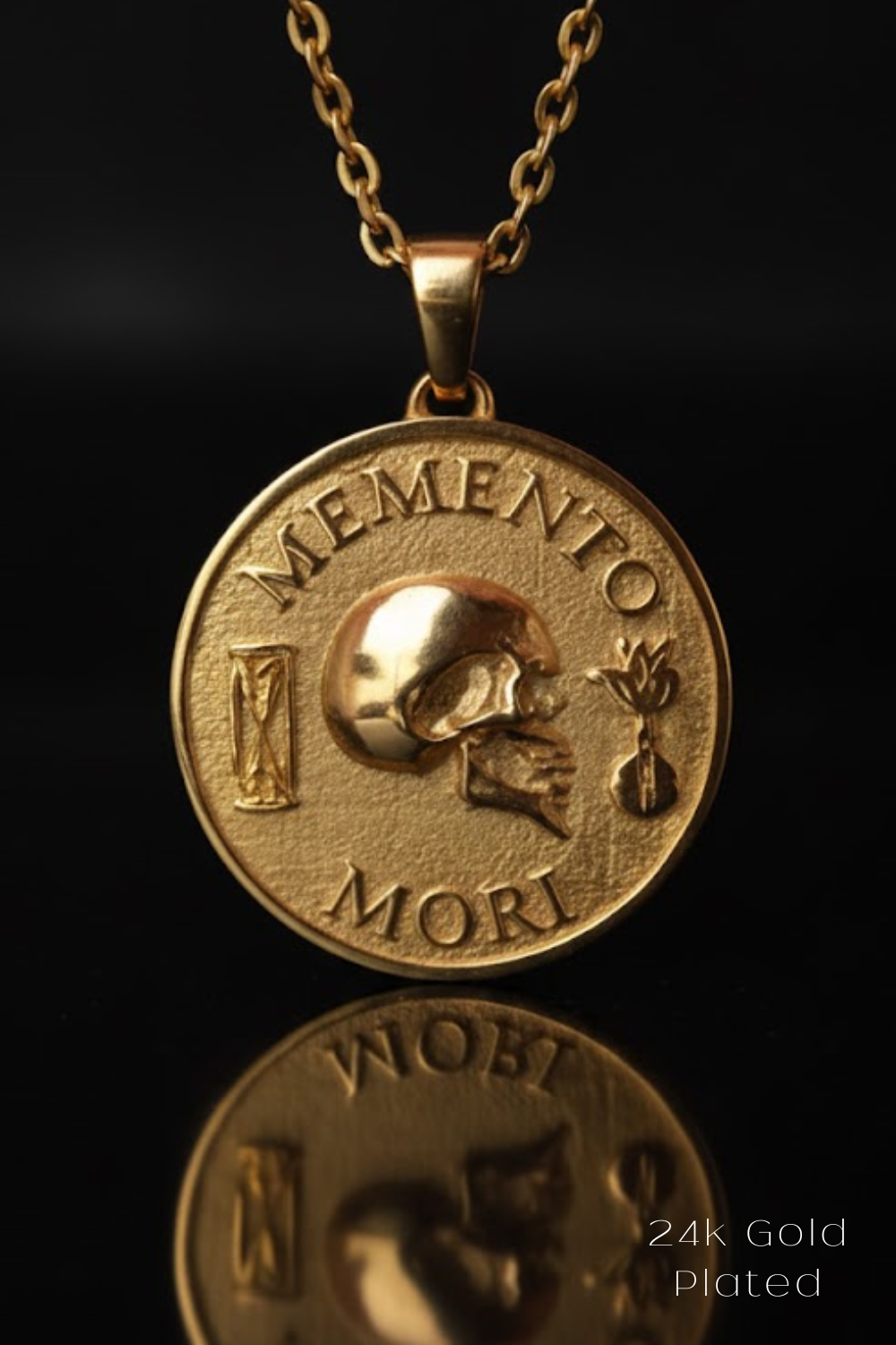 A gold-plated pendant necklace with a medallion-shaped design featuring a skull and the Latin phrase "Memento mori" (which means "Remembering the dead" in English).