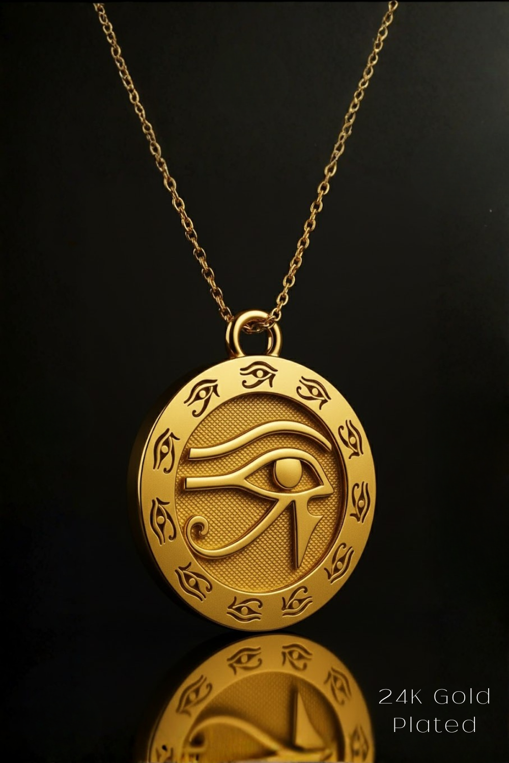 A gold-colored pendant necklace with an intricate design featuring an eye motif, displayed against a black background.