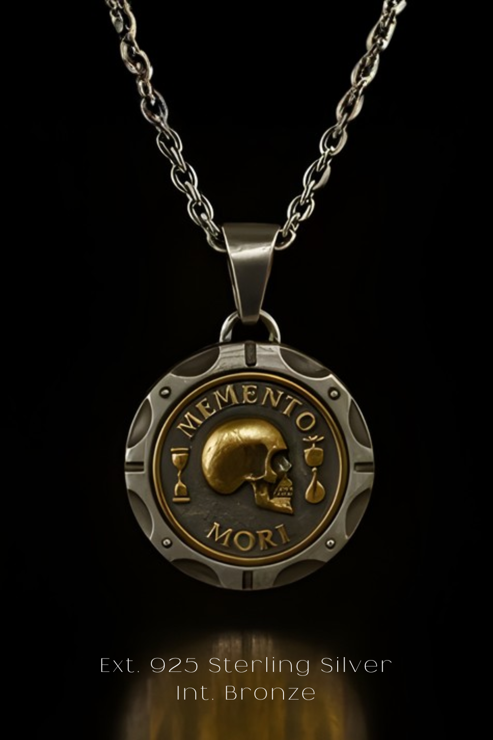 A silver necklace pendant with a circular design featuring a skull and the Latin phrase "Memento mori" (The Memory of Death).
