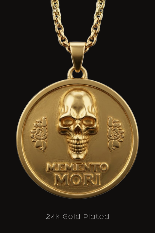 A 24k gold plated pendant featuring a skull design with the Latin phrase "Memento mori" inscribed below it.