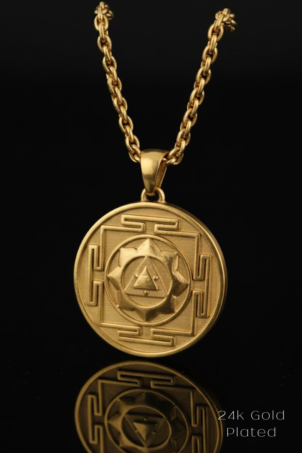 A 24k gold-plated pendant necklace with a circular medallion featuring an intricate design.