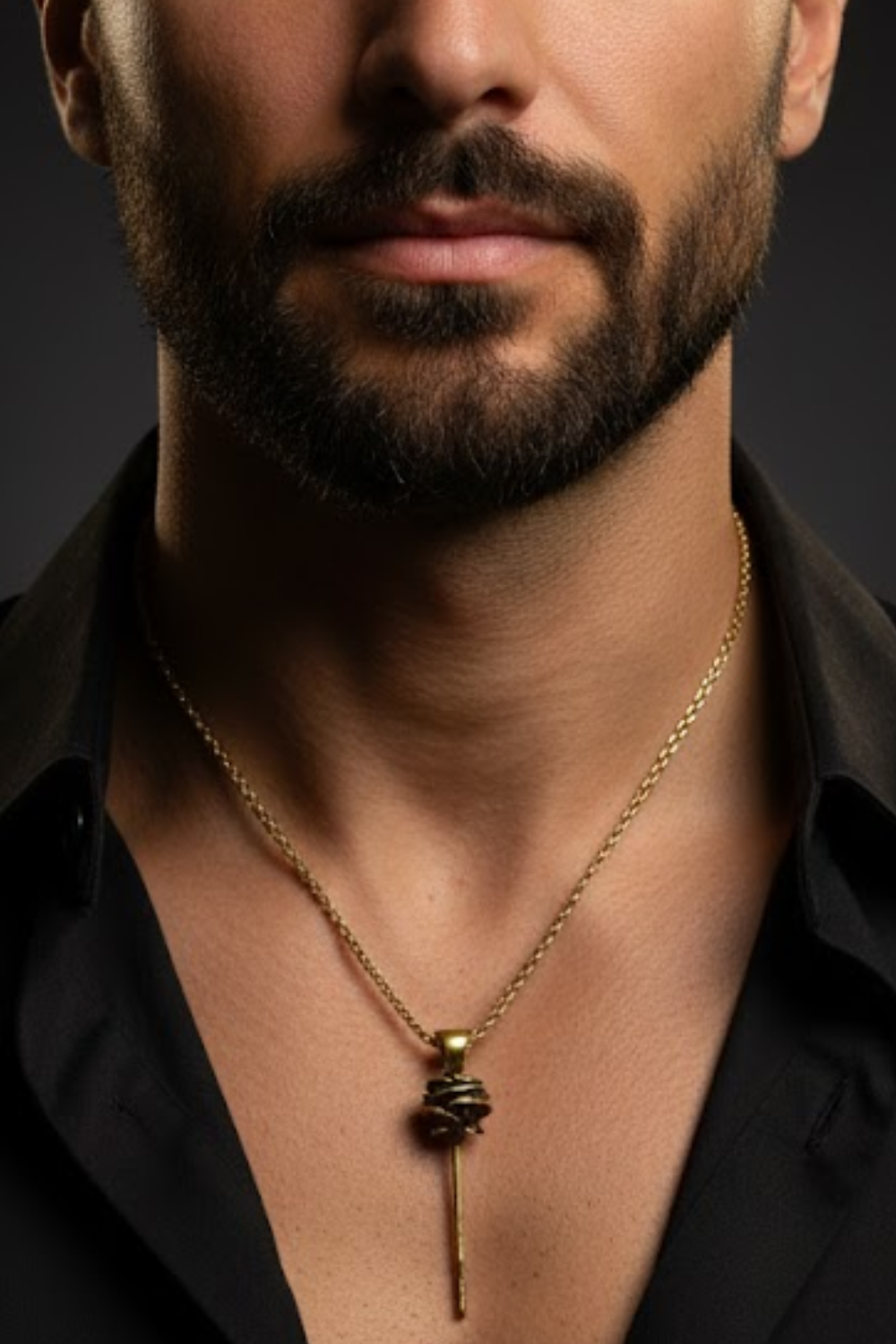 A close-up of a man's neck and chest area, with a gold necklace and a pendant visible.