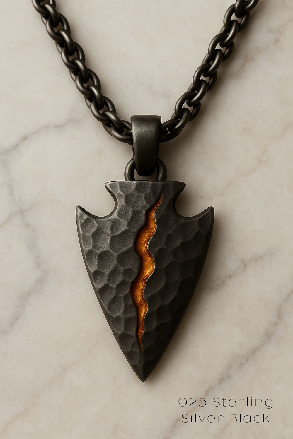 A black pendant with a carved design and a small orange stripe running through it, suspended from a chain.