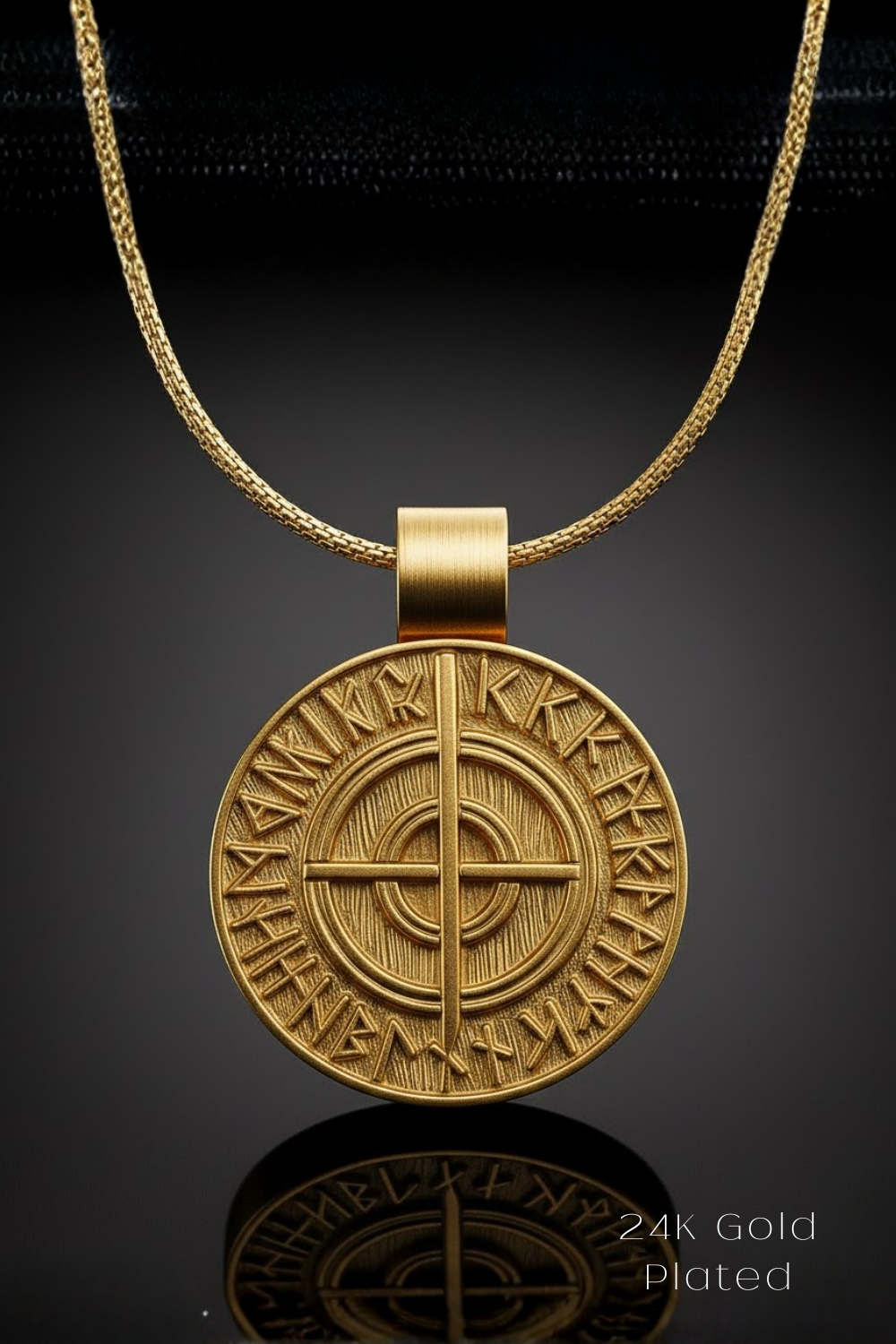 A gold-plated pendant necklace with a circular medallion featuring an intricate design and text.