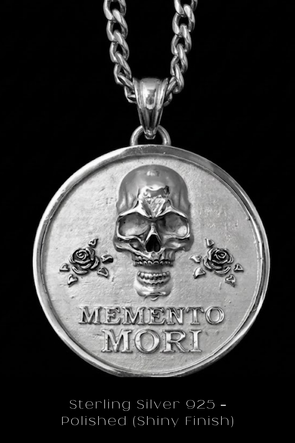 A silver-colored pendant necklace with a circular medallion featuring a skull design and the Latin phrase "Memento mori" (which means "Remembering the dead" in English).