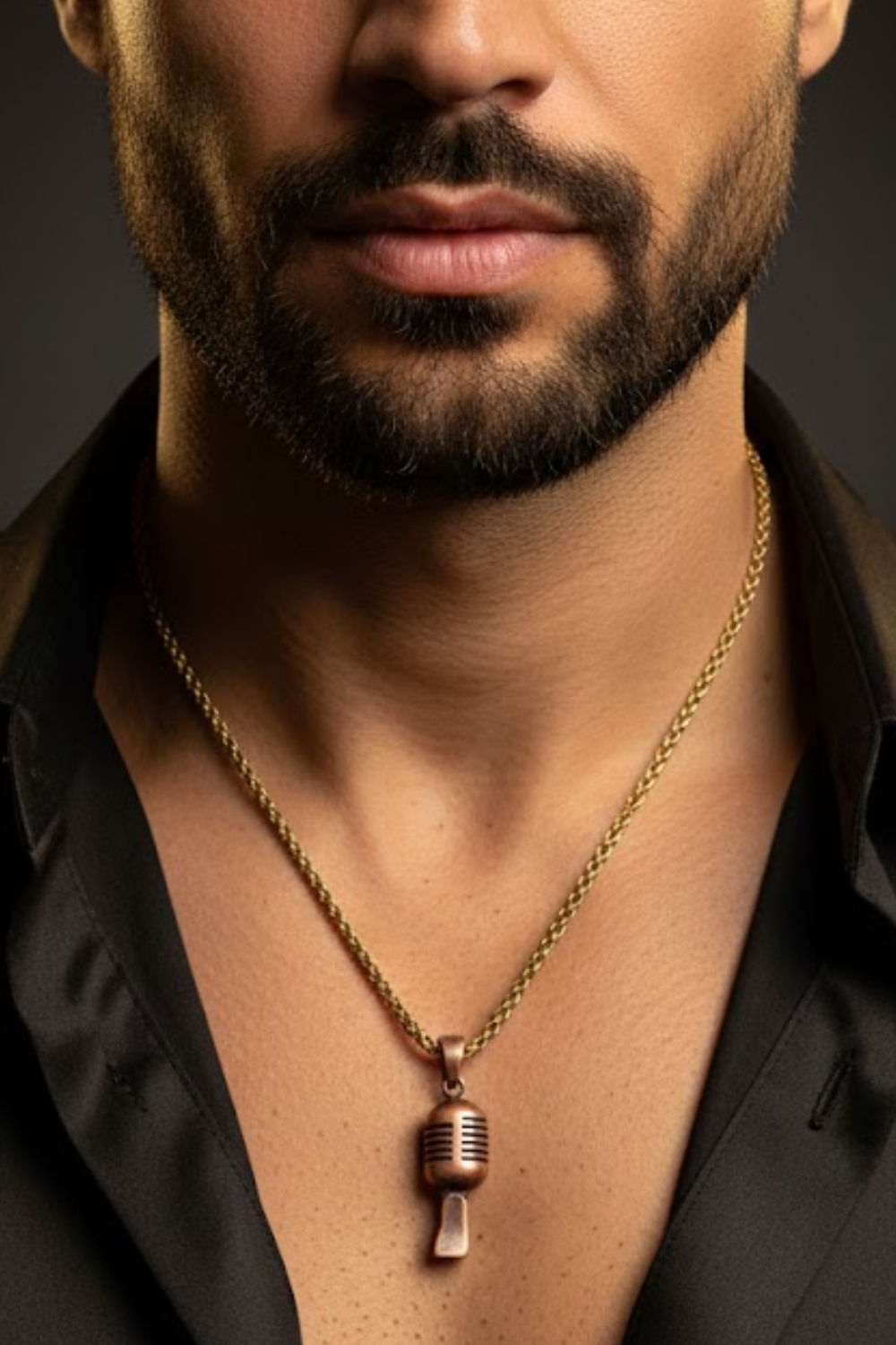 A close-up of a man's neck and chest area, with a gold necklace and a microphone pendant visible.