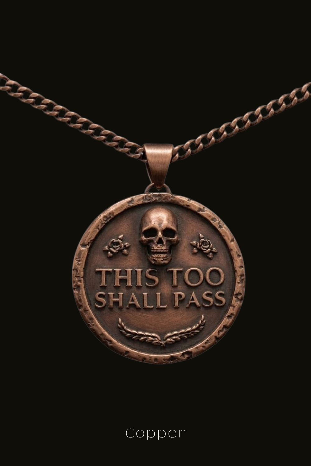 A copper-colored pendant necklace with a circular medallion featuring a skull and the text "THIS TOO SHALL PASS" in a bold, capitalized font.