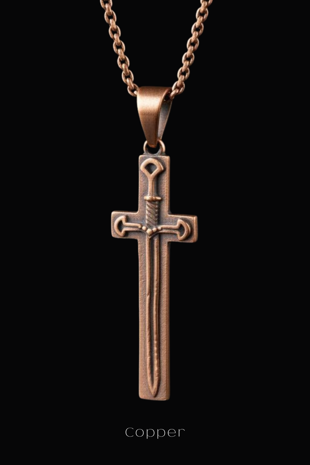 A copper-colored pendant in the shape of a cross, with a sword design, is displayed against a black background.