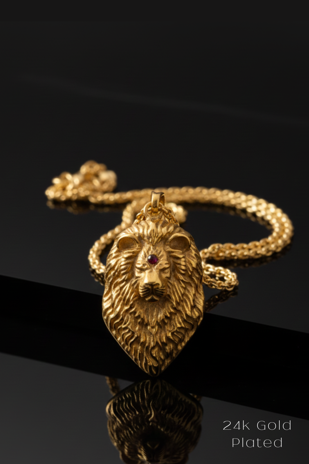 A 24k gold plated pendant in the shape of a lion's head is displayed against a black background, with a chain visible in the background.