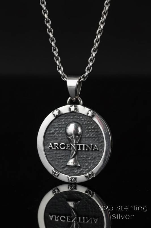 A silver pendant necklace with a circular design featuring the word "ARGENTINA" and a trophy icon, against a black background.