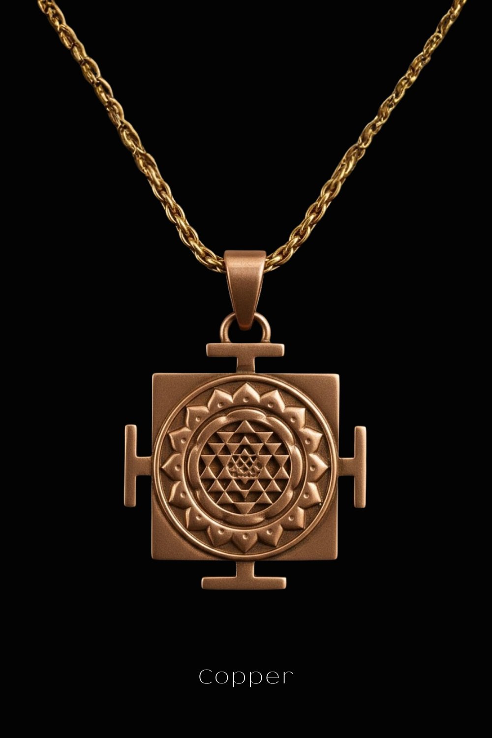 A copper-colored pendant with a geometric design, suspended from a chain against a black background.