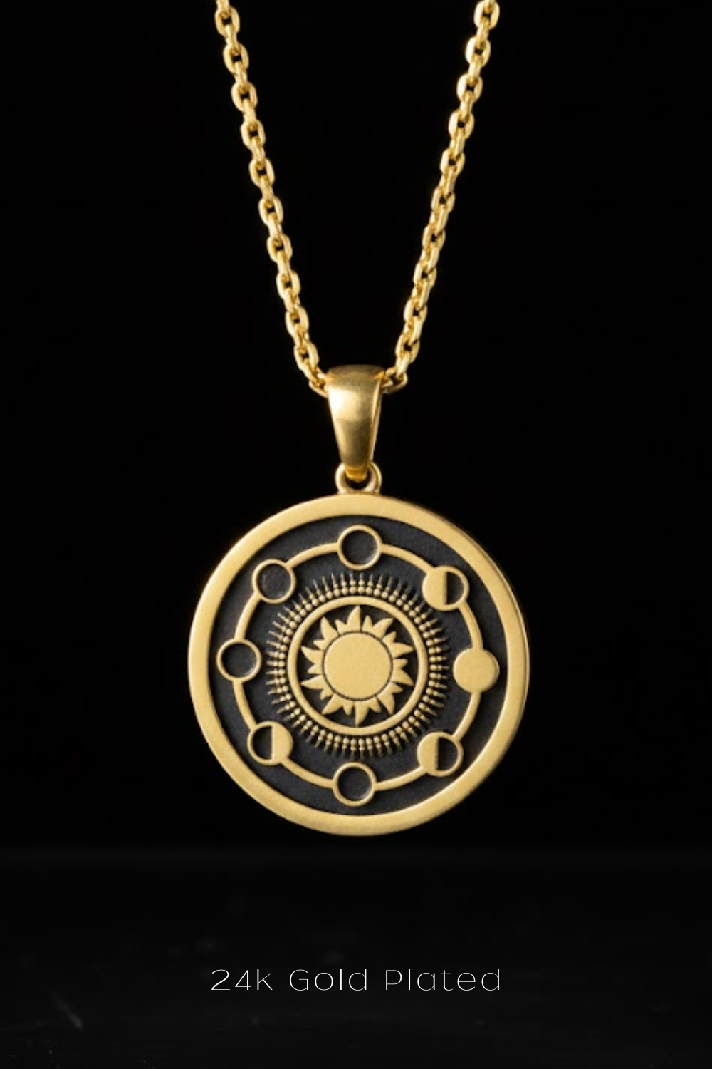 A gold-plated pendant necklace with a circular design featuring a sun and moon motif.