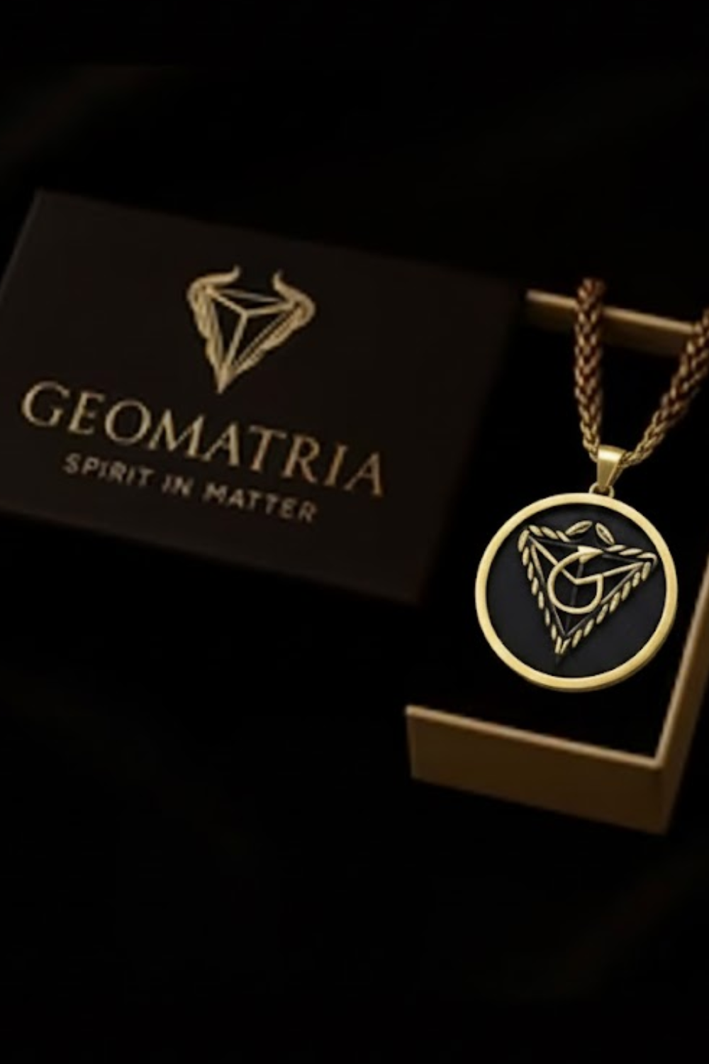 a pendant with a geometric design and a box with the text "Geomatria Spirit in Matter" on it, both placed against a dark background.