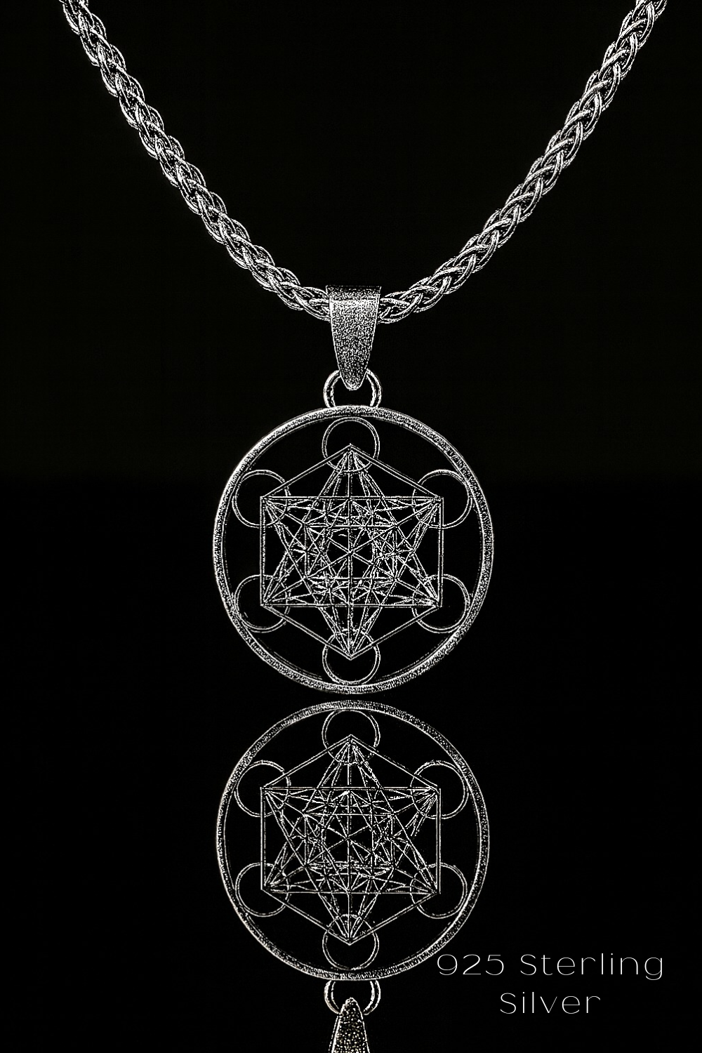 A silver necklace with a pendant featuring a geometric design, including a hexagon and a star-like shape.