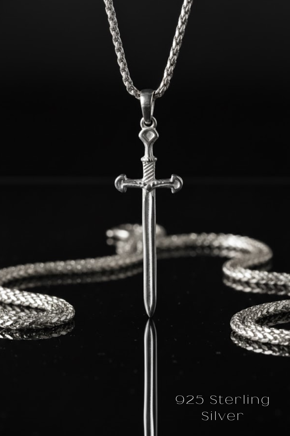A silver-colored sword pendant with a chain necklace is displayed against a black background.