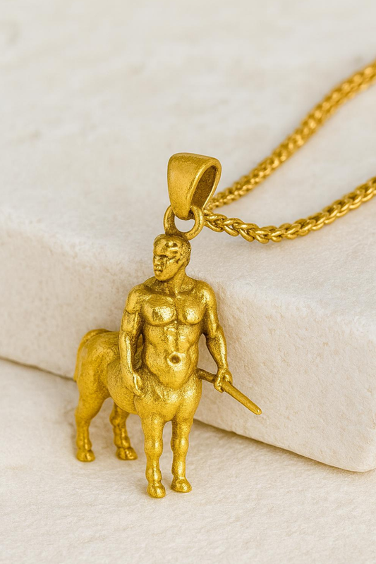 A gold-colored pendant in the shape of a muscular male figure, possibly a centaur, is displayed on a chain.