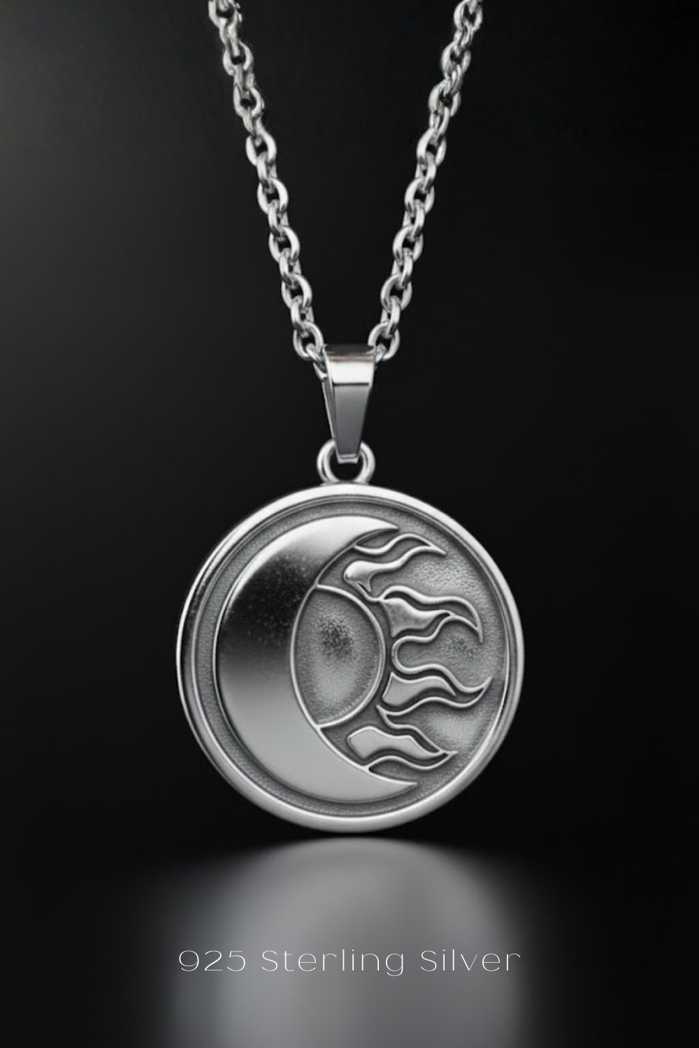 A silver pendant necklace with a circular design featuring a crescent moon and sun motif.