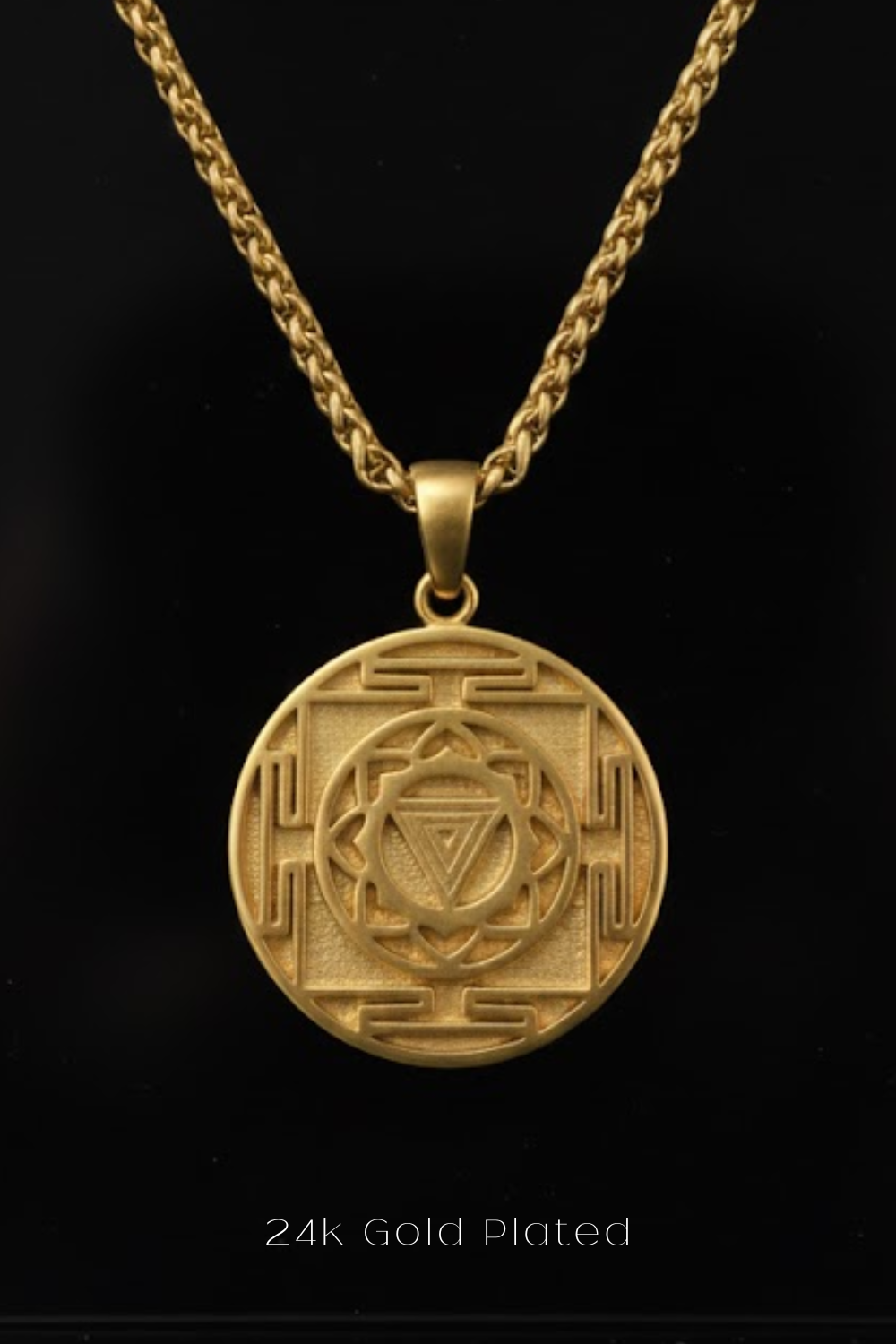 A gold-plated pendant necklace with a circular medallion featuring an intricate design.