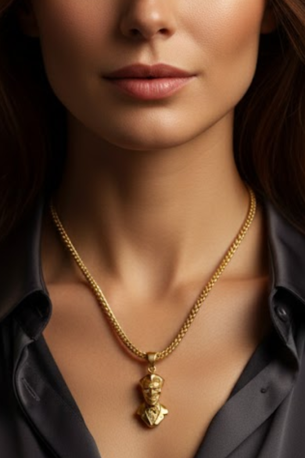 A close-up of a woman's neck and chest area, with a gold-colored necklace featuring a pendant.
