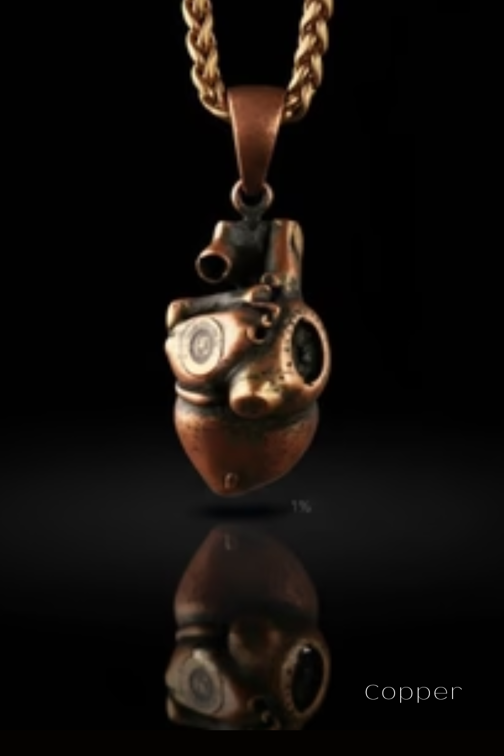 A copper-colored pendant with an intricate design hangs against a black background, reflecting on the surface below.