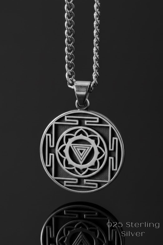 A silver pendant necklace with a circular design featuring a geometric pattern and a central symbol.