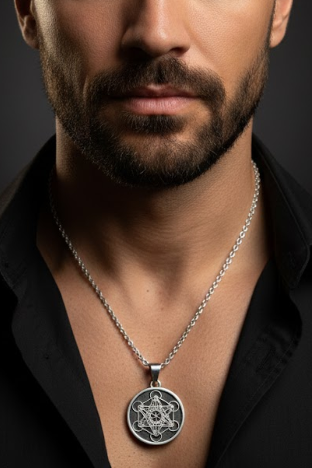 A close-up of a man's neck and chest area, with a silver necklace featuring a circular pendant hanging around his neck.