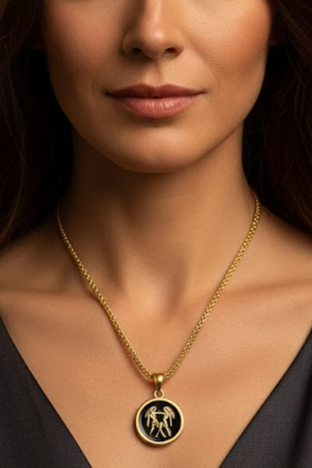 A close-up of a woman's neck and chest area, with a gold chain necklace and a pendant featuring a circular design.