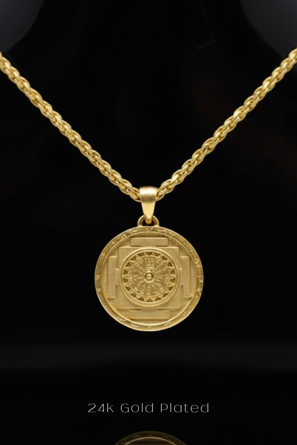 A gold-plated pendant necklace with a circular medallion featuring a detailed design.