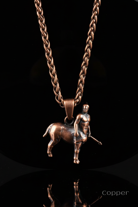 A copper-colored metal pendant necklace with a small statue of a man on a rearing horse, suspended from a chain.