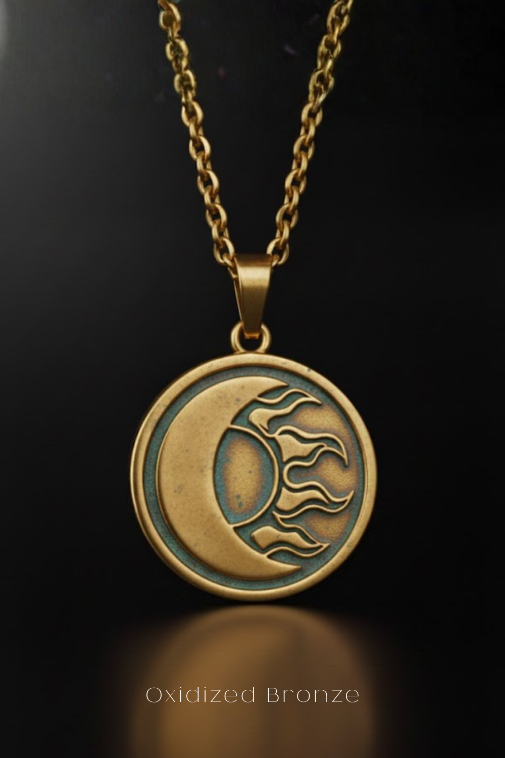 An oxidized bronze pendant necklace with a circular design featuring a crescent moon and sun motif.
