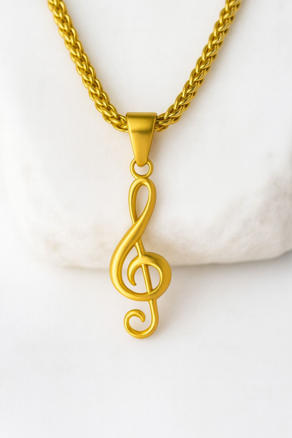 A gold-colored musical note pendant hanging from a chain necklace.