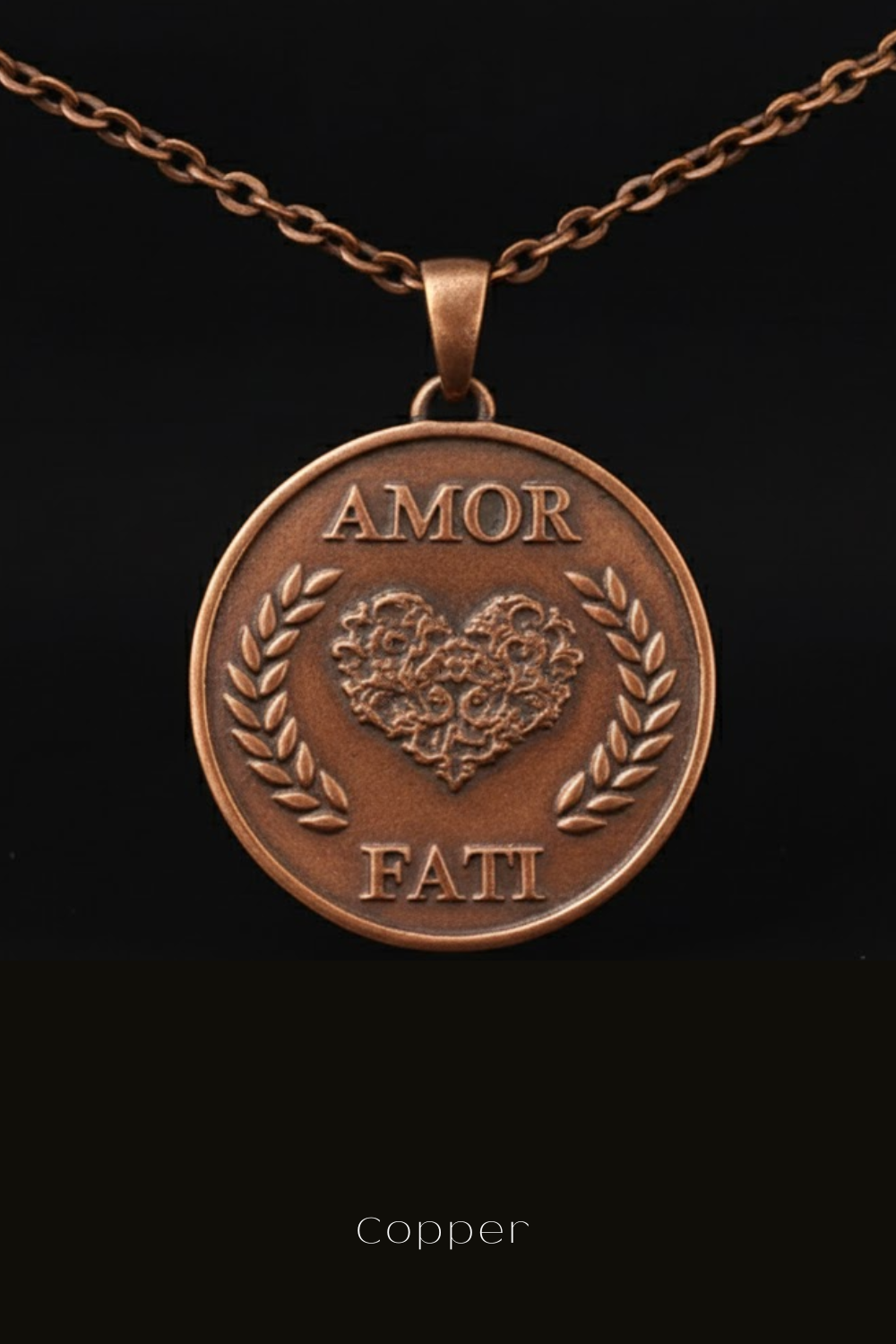 a copper-colored pendant necklace with a heart-shaped medallion at the center, surrounded by laurel wreaths. The pendant has the words "Amor Fati" inscribed on it.