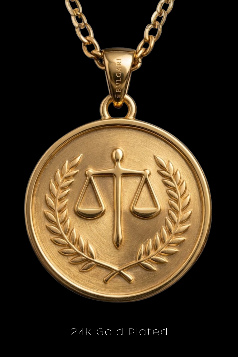 A 24k gold-plated pendant featuring a medallion-like design with a scale of justice symbol and laurel leaves.