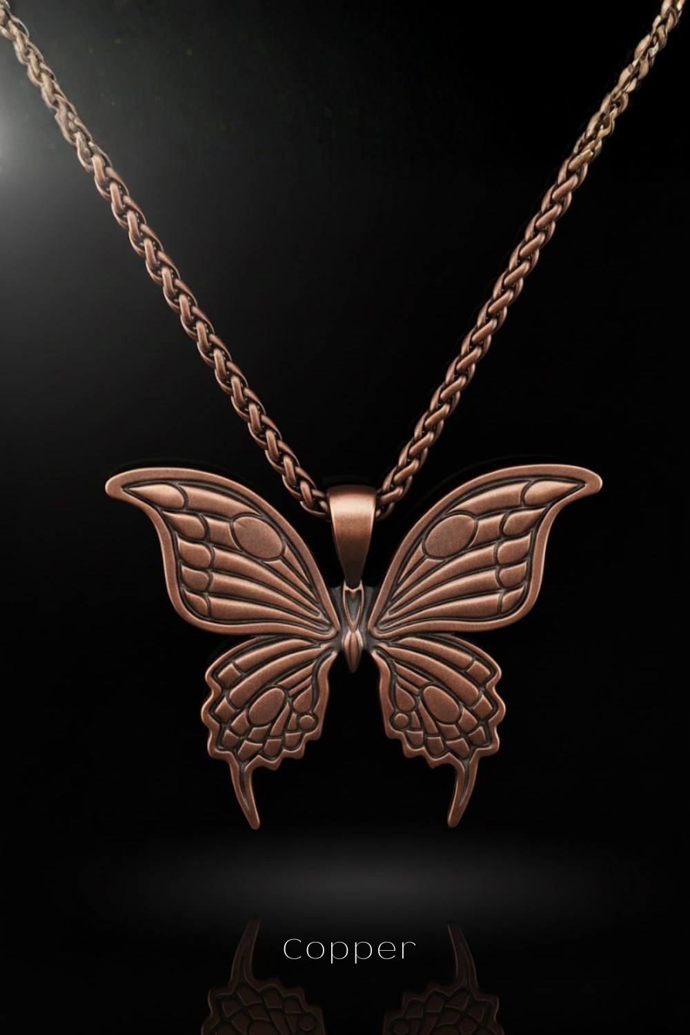 A copper-colored butterfly pendant necklace against a black background.